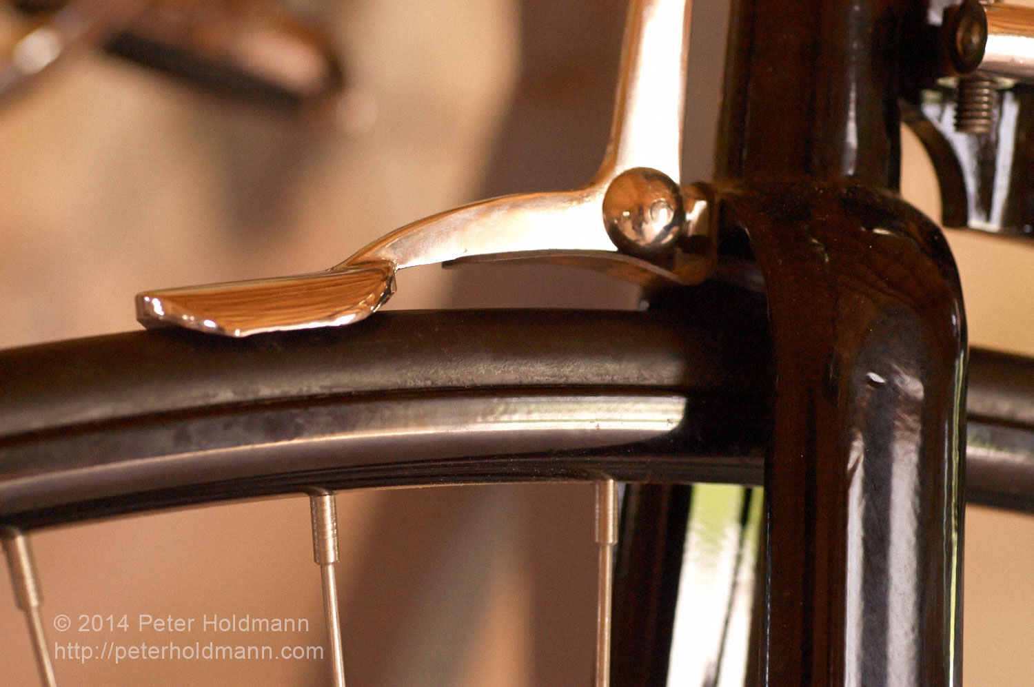 The brake, fork, and wheel with hard rubber tire on a high-wheel bicycle. 